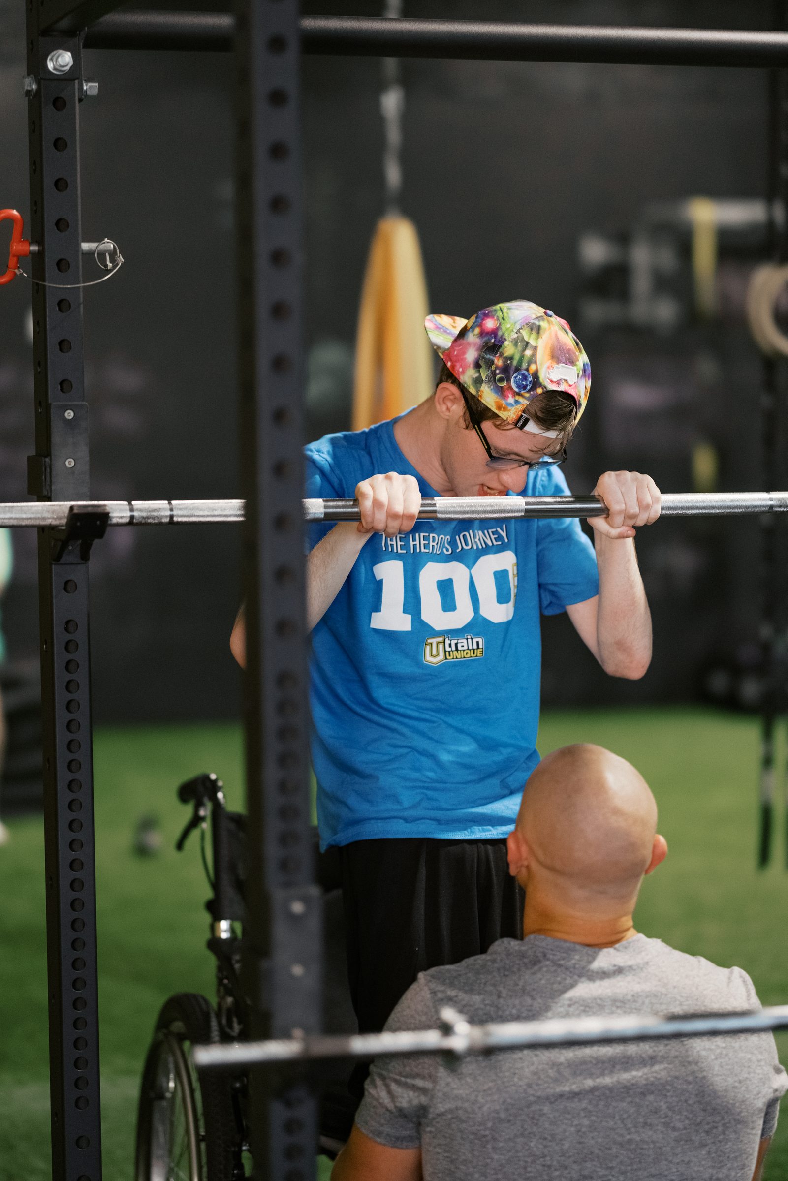 An athlete under the bar, coach close beside him